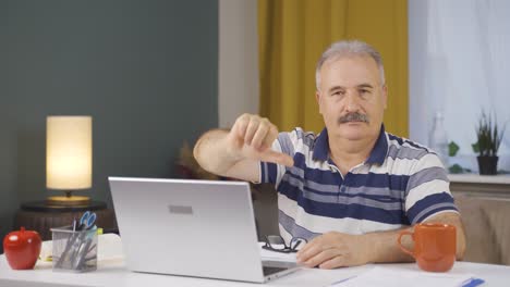 Home-office-worker-old-man-making-negative-gesture-at-camera.